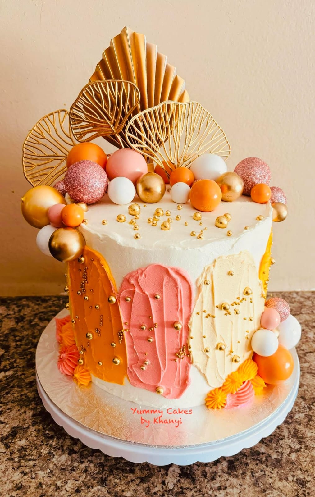 A beautifully decorated custom celebration cake coated in vibrant colours by Yummy Cakes by Khanyi